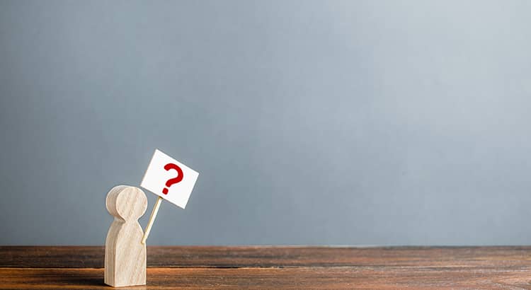 A small figure stands holding a large red question mark. The figure appears to be pondering the benefits of owning a home versus renting.